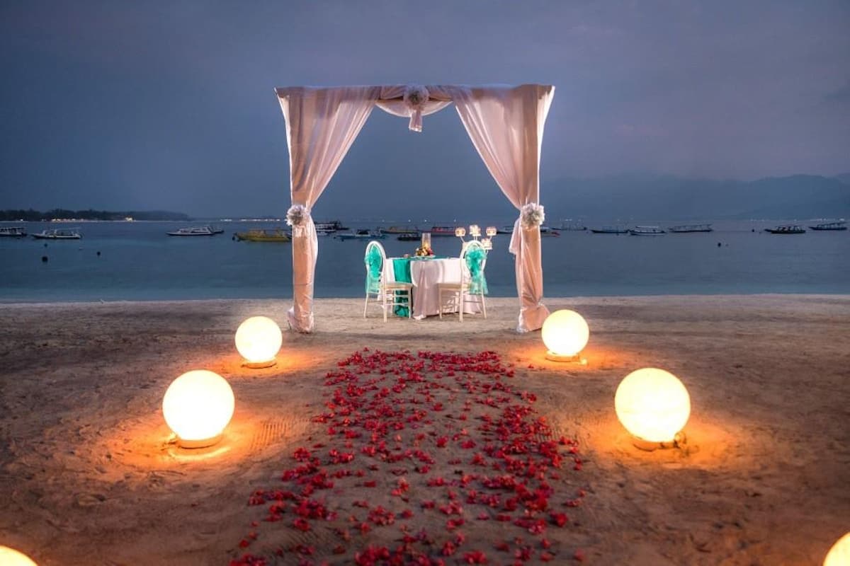 Pergola pantai Vila Ombak dihias globe coral dan jalur bunga